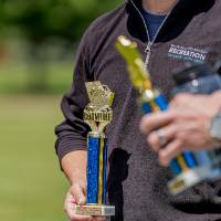 Members of the winning team hold their blue trophies